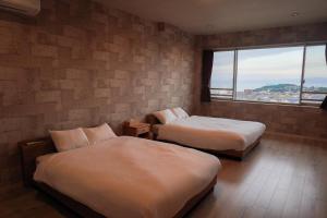 Postel nebo postele na pokoji v ubytování Beppu Ohana