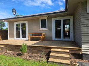 a house with a wooden porch with a bench on it at Modern, House in central Palmerston North in Palmerston North