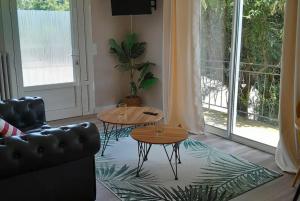 a living room with two tables and a couch at Chez Jade et Zoé in Ortholès +5 photos