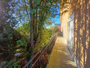 a fence next to a building next to a tree at Chez Jade et Zoé in Ortholès