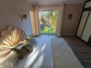 a bedroom with a white bed and a large window at Chez Jade et Zoé in Ortholès