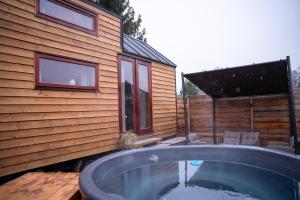 Nové HradyTiny house s vyhřívacím koupacím sudem的房屋旁带热水浴池的后院