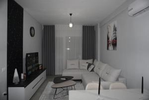 a white living room with a couch and a table at DREAM Apartment in Kamëz