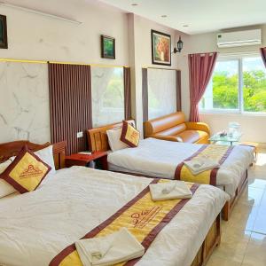 a hotel room with three beds and a couch at 999 Hotel Lào Cai in Yên Bái +38 photos