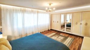 een slaapkamer met een blauw bed en een kroonluchter bij Villagalicia360 in Bergondo