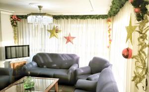 a living room with a blue leather couch and a television at Villagalicia360 in Bergondo
