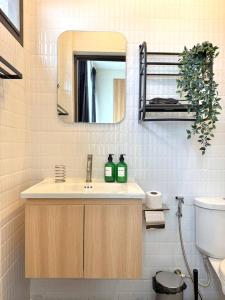 een badkamer met een wastafel en een spiegel bij Office 3 in Bangkok