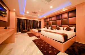 a hotel room with two beds and a television at Hotel Golden Palace in Kolkata +75 photos