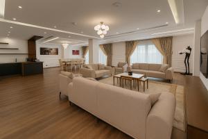 una amplia sala de estar con sofás y una mesa en Blue Moon Hotel, en Erbil