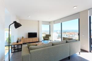 een woonkamer met een bank en een televisie bij Villa view bay with Jacuzzi in Salir de Porto