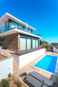een huis met een zwembad ervoor bij Villa view bay with Jacuzzi in Salir de Porto
