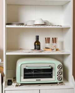 une cuisine avec un mini-four vert dans un placard dans l'établissement Bari Antica Boutique B&B, à Bari