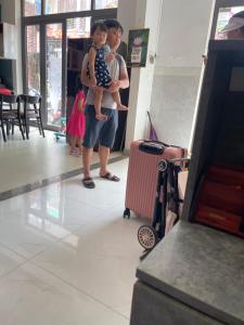 a man and a woman holding a child in an airport at Tự Do Homestay Huế in Hue