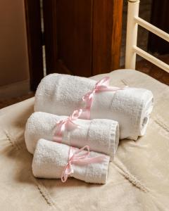 trois serviettes avec un ruban rose sur un lit dans l'établissement Bari Antica Boutique B&B, à Bari 223 autres photos
