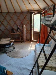 a room with a bunk bed and a window at La Yourte Des Abeilles in Les Preyrauds