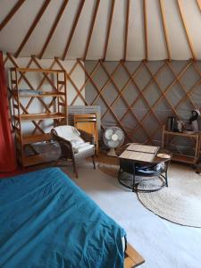 a room with a bed and a table in a yurt at La Yourte Des Abeilles in Les Preyrauds