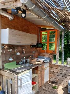 an outdoor kitchen with a sink and a stove at La Yourte Des Abeilles in Les Preyrauds