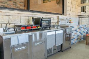 una cocina con estufa y microondas en לה וילה - וילה משפחתית עם בריכה פרטית מחוממת ומקורה, en Bet Dagan