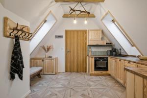 Una cocina con gabinetes de madera y una escalera con tragaluces. en Apartamenty Odkryj-Bialke, en Białka Tatrzanska
