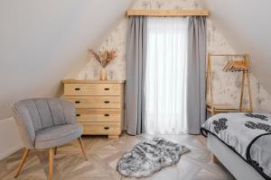 a bedroom with a bed and a chair and a dresser at Apartamenty SKI Apartments, Odkryj-Bialke in Białka Tatrzańska +44 photos