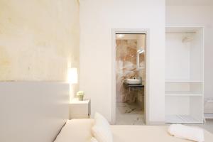 a white living room with a couch and a sink at Costa Private room in Castelsardo