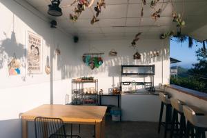 Un restaurante con una mesa y sillas y un mostrador. en THỎ NON GARDEN CLOUDY OCEAN VIEW, en Blao Srê