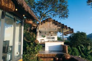 una cocina al aire libre en una casa con un árbol en THỎ NON GARDEN CLOUDY OCEAN VIEW, en Blao Srê