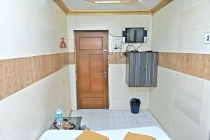 Habitación con puerta y TV en la pared en Hotel Ajanta, en Bombay