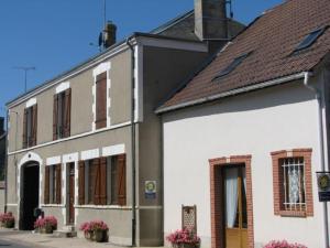 a white building with flowers in front of it at "Chambre Rose", L'Ancienne Poterie in Nancray-sur-Rimarde