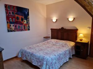Nancray-sur-Rimardeにある"Chambre Rose", L'Ancienne Poterieのベッドと壁に絵が飾られた寝室