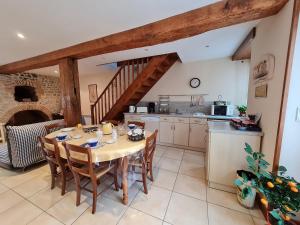 a kitchen and dining room with a table and chairs at "Chambre Rose", L'Ancienne Poterie in Nancray-sur-Rimarde