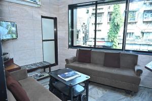 una sala de estar con un sofá y una mesa en Hotel Ajanta, en Bombay