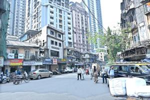 una concurrida calle de la ciudad con gente cruzando la calle en Hotel Ajanta, en Bombay