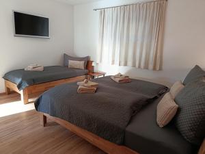 een slaapkamer met twee bedden met handdoeken erop bij Ferienwohnung Vogelsang in Stans