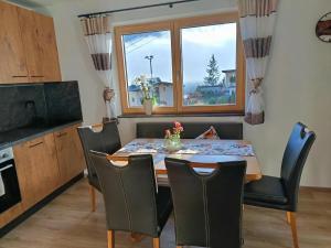een eetkamer met een tafel en stoelen en een raam bij Ferienwohnung Vogelsang in Stans +28 foto's