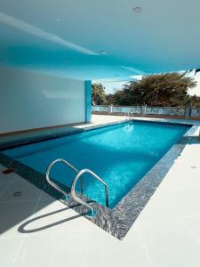 a blue swimming pool with a hand rail in a building at Naia Residence - 2BR Oceanview in Dar es Salaam