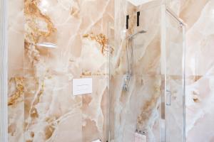 a shower in a bathroom with a marble wall at Costa Private room in Castelsardo