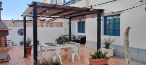 un patio esterno con tavolo e sedie bianchi di Casa Luz a Costa Calma