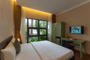 a bedroom with a bed and a desk and a window at MOONLIGHT Homestay & Hotel in Pleiku