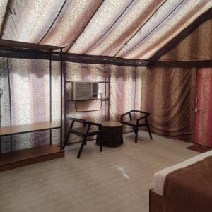 a room with a tent with a bed and a table at Sandscapes Sam Jaisalmer by ADB Hospitality in Jaisalmer