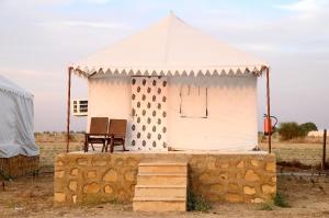 a white tent sitting on top of a stone wall at Sandscapes Sam Jaisalmer by ADB Hospitality in Jaisalmer