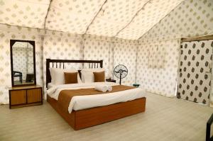 a bedroom with a large bed and a mirror at Sandscapes Sam Jaisalmer by ADB Hospitality in Jaisalmer +66 photos