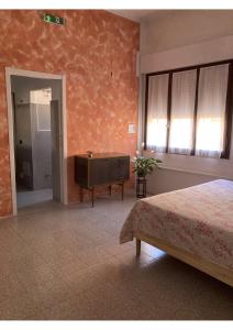 een slaapkamer met een bed, een ladekast en een raam bij Portale dei Soli 2 in Rolo