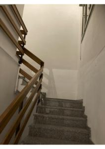 een trap in een gebouw met een houten leuning bij Portale dei Soli 2 in Rolo