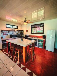 a large kitchen with a large table and stools at Valle del Arenal House Family Home in La Fortuna in Fortuna