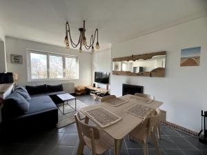 a living room with a table and a couch at Appartement face Nausicaa in Boulogne-sur-Mer