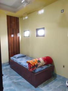 a small bed in a room with two windows at Hotel Star, Agartala in Agartala +1 photo