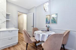 Большая двухкомнатная Люкс возле вокзал НУРЛЫЖОЛ في أستانا: غرفة طعام بها طاولة وكراسي +6 صور