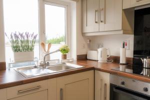 a kitchen with a sink and a window at Carnglas, Gweedore, County Donegal in Donegal