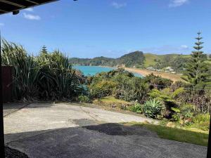 a driveway with a view of a body of water at Ocean view haven in Matapouri